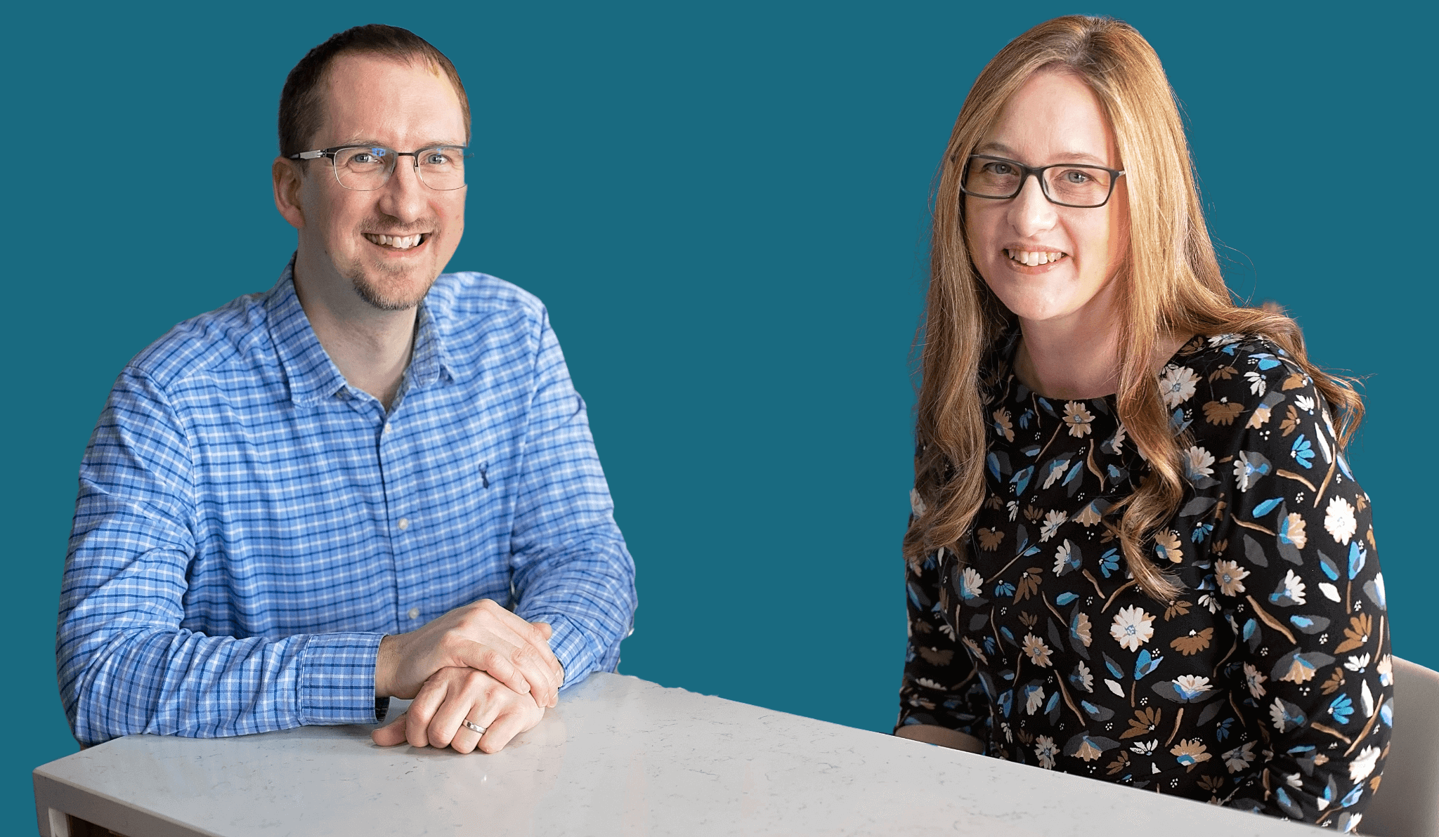 Mike and Li sitting at a table, smiling into the camera